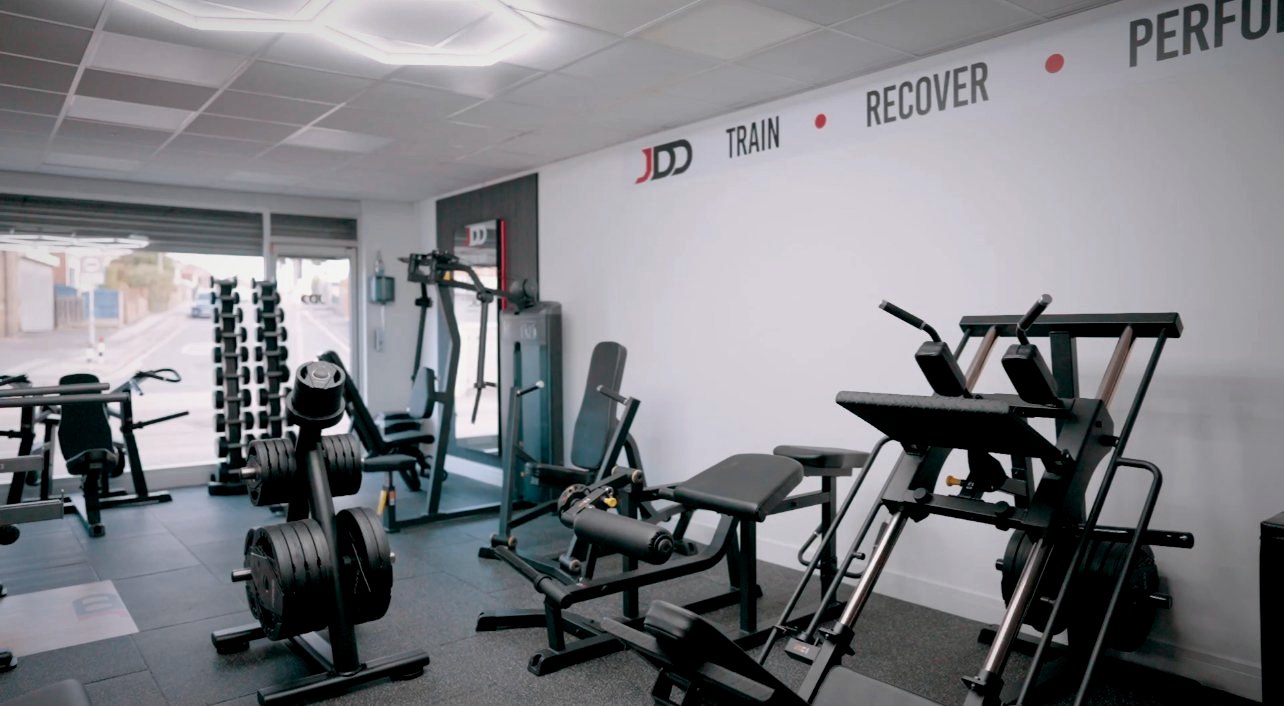 Train, Recover, Perform written on the wall above the machines
